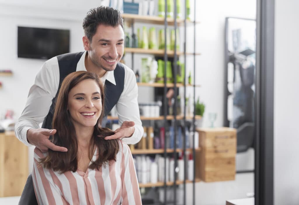 Male Hairstylist with female customer in salon studio suite